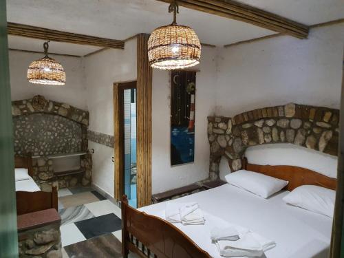 a bedroom with a bed and two chandeliers at Maxola's Dream Orikum in Orikum