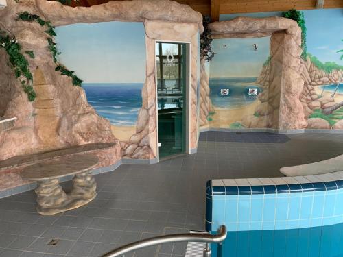 a bathroom with a rock wall and a bath tub at Ryck-Hotel Garni in Greifswald