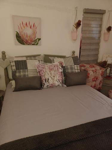 Shalom guesthouse في بلومفونتين: سرير كبير في غرفة عليها وسائد
