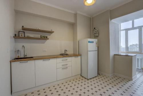 a kitchen with white cabinets and a refrigerator at Quite apartment in Bishkek
