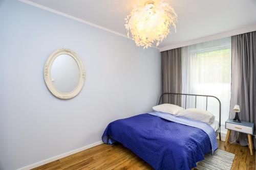 een slaapkamer met een bed en een spiegel bij River House - J&D Apartamenty in Szczecin
