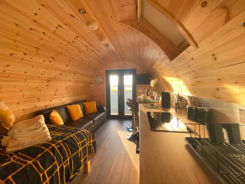 a room with a bed and a couch in a cabin at The Sandy Pod in Stornoway