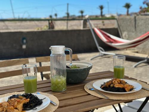 a table with two plates of food and a bowl of green juice at Casa do Profeta in Porto Santo