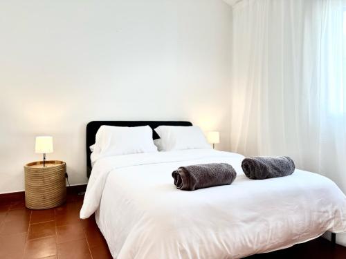 a bedroom with a white bed with two pillows on it at Casa do Profeta in Porto Santo