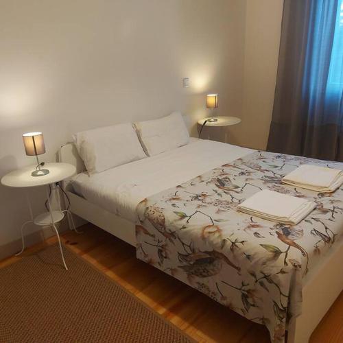 a bedroom with a bed with two tables and two laptops on it at Boho House Terrace in Porto