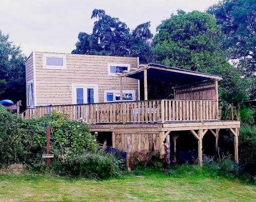 duży drewniany dom z dużym tarasem w obiekcie The Wee Tiny Home w mieście Eglinton