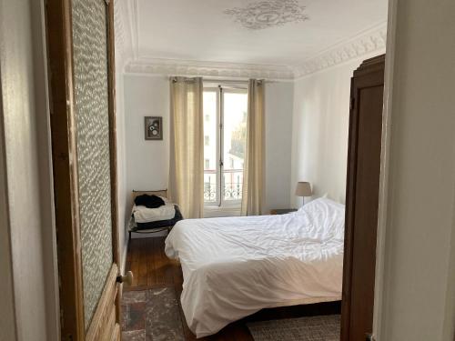 a small bedroom with a bed and a window at Love Nest In Paris in Paris