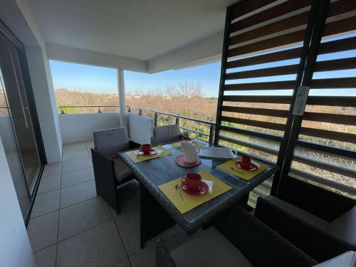 Cette chambre dispose d'une table, de chaises et d'un balcon. dans l'établissement Studio cabine neuf avec terrasse proche plage et centre, parking privé inclus - FR-1-250-185, au Grau-du-Roi