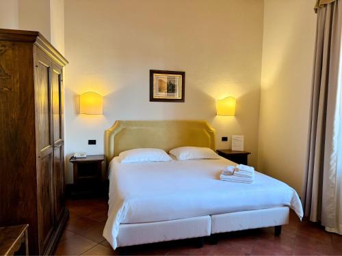 een slaapkamer met een groot wit bed en 2 nachtkastjes bij Hotel Relais Il Cestello in Florence