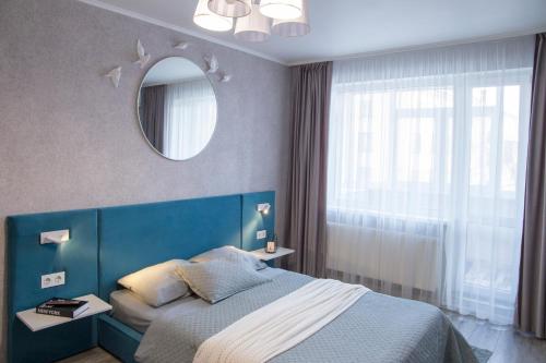 卡爾可夫的住宿－Аппартаменты Металлист посуточно VIP，一间卧室配有蓝色的床和镜子