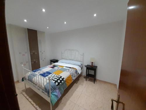 um quarto com uma cama num quarto branco em SWEET HOUSE CLOSE TO AIRPORT em Barcelona