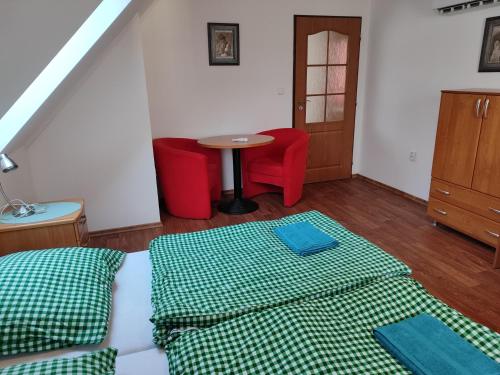 a bedroom with a bed and a table with red chairs at Chaty Koloděje - oranžový dům in Koloděje nad Lužnicí