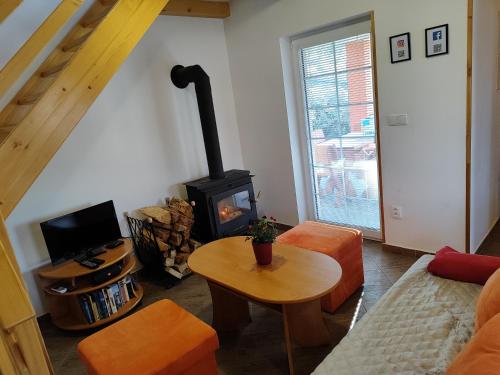 a living room with a wood stove in it at Chaty Koloděje - oranžový dům in Koloděje nad Lužnicí