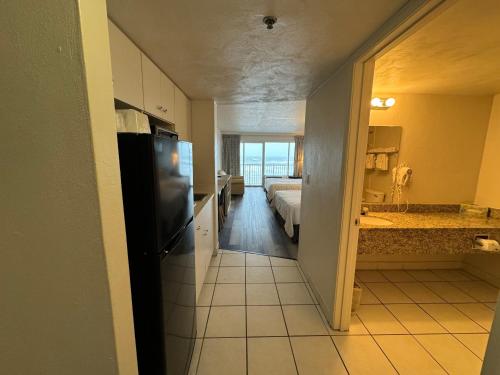 une chambre avec une cuisine et une chambre avec un lit dans l'établissement Emerald Shores Hotel - Daytona Beach, à Daytona Beach