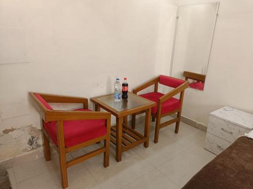 uma pequena mesa e duas cadeiras com garrafas em The Craft Hotel and Restaurant em Pānīpat