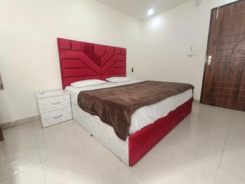 uma cama grande com uma cabeceira vermelha num quarto em The Craft Hotel and Restaurant em Pānīpat
