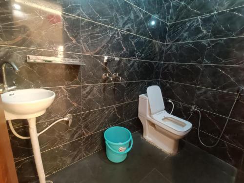 uma casa de banho com um lavatório e um WC em The Craft Hotel and Restaurant em Pānīpat