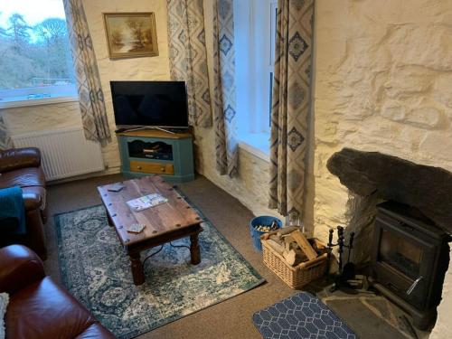 a living room with a fireplace and a television at Cosy Two Bedroom Cottage with Fireplace in Colwyn Bay