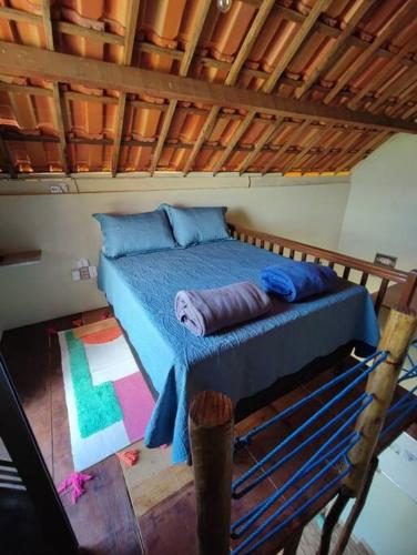 a bedroom with a blue bed with a wooden ceiling at Caridade Loft in Monte das Gameleiras