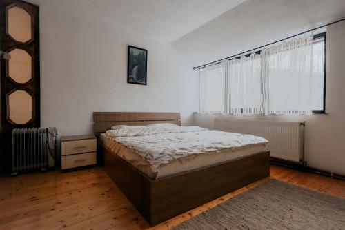 a bedroom with a bed and a large window at SpringChillVillaBrezovica in Prevalla