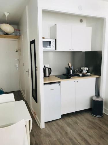 une cuisine avec des armoires blanches et un comptoir dans l'établissement Studio neuf à 3 mn du Stade Vélodrome & Hôpital St Joseph, à Marseille