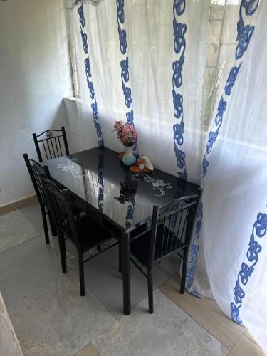 une table à manger avec deux chaises et une fenêtre dans l'établissement Diani cozy studio apartment, à Ukunda