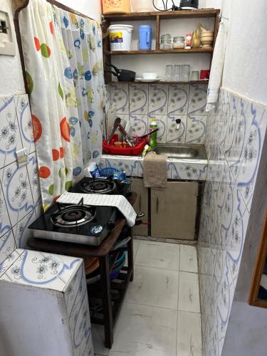 Il comprend une petite cuisine équipée d'une cuisinière et d'un évier. dans l'établissement Diani cozy studio apartment, à Ukunda