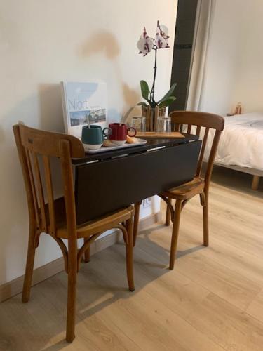 a table and two chairs in a room with a bed at Chambre spacieuse lit King Size in Niort
