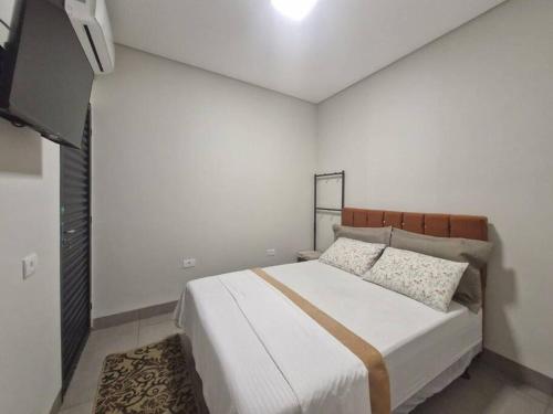 1 dormitorio con 1 cama grande en una habitación blanca en LOFT D Hospedagem Cidade Verde D, en Maringá