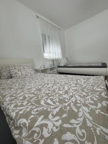 a bedroom with a large bed with a pattern on it at Apartment Vlora-Naturblick in Villach