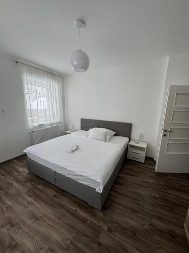 um quarto branco com uma cama e uma janela em Apartment Vlora-Naturblick em Villach