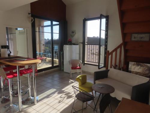 un salon avec un canapé, une table et des chaises dans l'établissement Gruissan Village APPT Duplex 51m2, à Gruissan