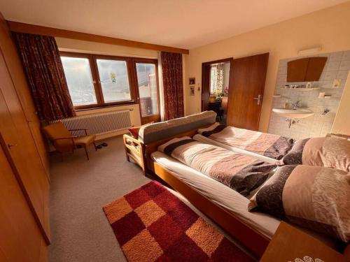 a bedroom with two beds and a bathroom with a sink at Ferienhaus Heimatplatzle in Oetz