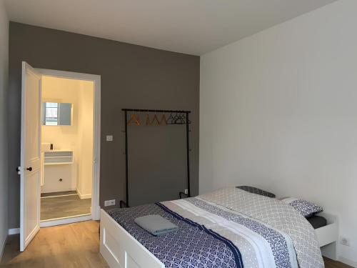 une chambre avec un lit et une porte donnant sur une salle de bain dans l'établissement Magnifique appartement - Hyper centre Vieux Cognac, à Cognac
