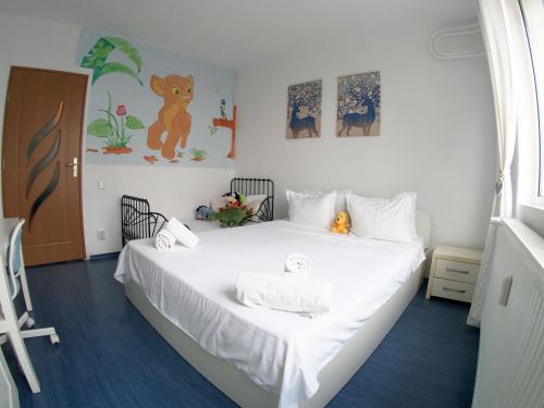 ein kleines Schlafzimmer mit einem weißen Bett und Bildern an der Wand in der Unterkunft Casa carților - House of book’s in Bukarest