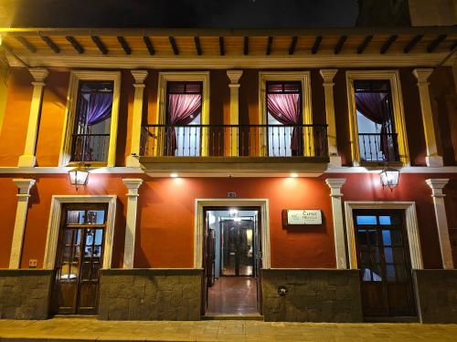 um edifício com uma varanda em cima em Casa Hibiscus Boutique Hotel em Cuenca