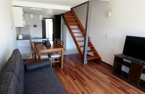 een woonkamer met een bank, een bureau en een trap bij Duplex Quinta Luna in Bariloche