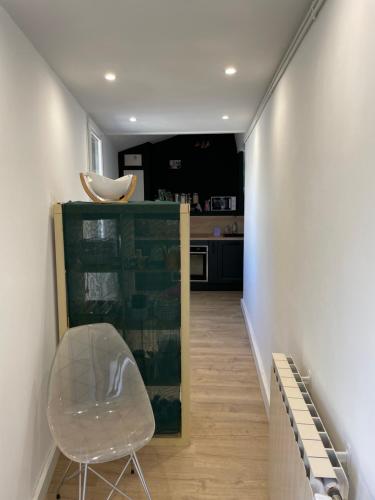 un couloir avec une chaise et une cuisine dans l'établissement Petite maison de ville avec jardin quartier calme, à Nîmes