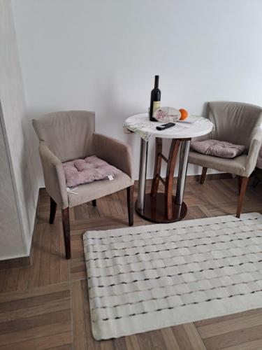 a table and two chairs and a table with a bottle of wine at Apartmani Emily & Jully in Nikšić