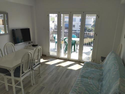 a living room with a table and chairs and a television at Casa Blanca in Oliva