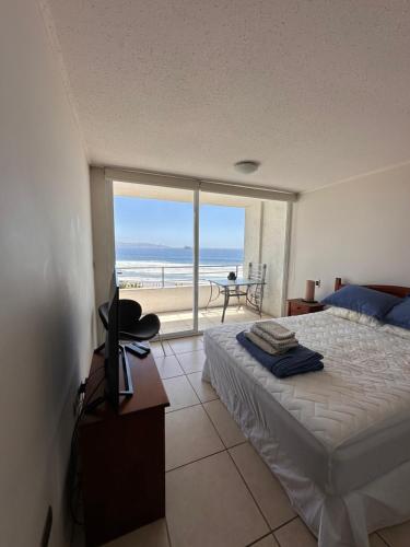 a bedroom with a bed and a view of the ocean at Mar Serena vista al Mar in La Serena