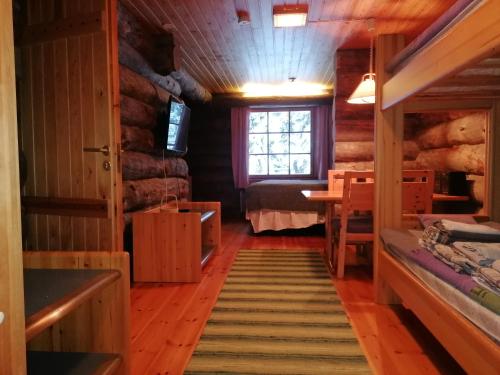 een kamer in een blokhut met een bed en een raam bij Kelo Seasons Autumn in Luosto