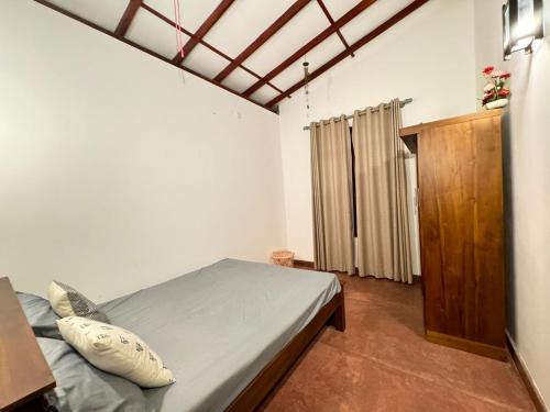 1 dormitorio con 1 cama y armario de madera en Serenique Heaven, en Hikkaduwa