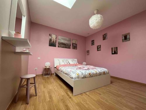 une chambre avec un lit et un mur rose dans l'établissement Maison 3 chambres à Cutry, à Cutry