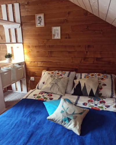 a bed with pillows on it in a room at Rodzinny zakątek "U Głuszków" Bieszczady in Myczkowce
