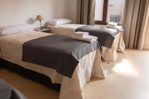 two beds in a hotel room with towels on them at Hotel Cerros del Norte in Tilcara