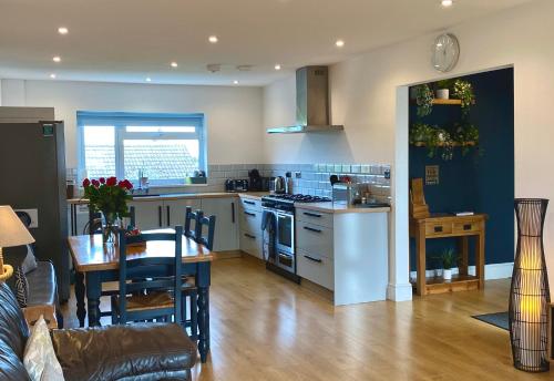 a kitchen and living room with a table and a kitchen and a dining room at Bungalow33 Benllech in Benllech