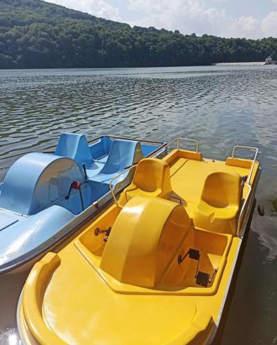a yellow and blue boat on a body of water at Rodzinny zakątek "U Głuszków" Bieszczady in Myczkowce
