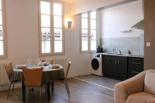 un salon avec une table et une cuisine dans l'établissement Magnifique appartement - Hyper centre Vieux Cognac, à Cognac