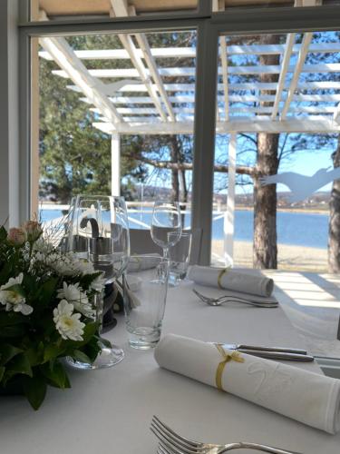 una mesa con mantel blanco y copas de vino en Garni hotel Oblačinsko jezero, en Oblačina